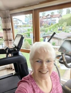 Simone Fahning lächelt im Fitnessraum während ihrer THE MAY50K-Challenge. Mit Multipler Sklerose sammelt sie Schritt für Schritt Kilometer für die MS-Forschung.
